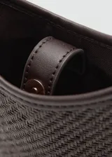 Bandolera porta celular Mango modelo Bilmacho de color marrón oscuro, con cuerpo de tejido texturizado y detalles en cuero sintético, cierre de botón magnético y correa ajustable desmontable.