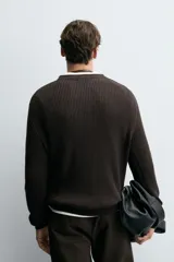 Sweater de punto en canalé color negro, de corte regular fit, cuello redondo y manga larga con terminaciones en rib.
