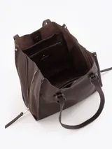 Bolso tipo tote de cuero color tostado con doble asa de hombro, detalles de hebillas metálicas en el frente y cierres laterales decorativos.