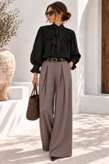 Pantalón de vestir color beige, de corte wide leg, tiro alto con pinzas frontales y presillas para cinturón. Incluye un cinto negro con hebilla metálica redonda dorada.