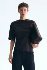 Remera marrón de punto suave de algodón, con cuello redondo, mangas cortas amplias y diseño asimétrico con frunce lateral.
