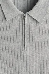 Remera polo de punto acanalado fino, con cuello clásico, medio cierre frontal y mangas cortas. Presenta un diseño entallado con bajo recto.