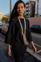 Jersey de punto liso color bordó, con cuello redondo y mangas anchas de largo tres cuartos. Presenta acabados en rib en cuello, puños y ruedo.