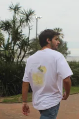Remera de algodón blanco, de corte recto y mangas cortas, con estampado pixelado en la espalda que representa un trago de limonada y la frase "summer flavor".