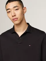 Chomba de manga larga Tommy Hilfiger color negro, confeccionada en algodón. Presenta cuello tipo polo, tapeta de dos botones y logo bordado en el pecho.