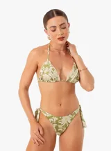 Conjunto de bikini verde con estampado floral blanco. El corpiño es de triángulo con volados y la bombacha es de corte clásico con lazos laterales.
