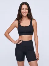 Top deportivo negro con escote redondo y detalle de malla en el centro del pecho, de diseño ajustado y tirantes anchos.