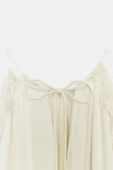 Vestido largo ZARA Woman Collection confeccionado en hilatura de viscosa de color crudo, con cuello halter, tirantes finos, detalles de encaje a tono y bajo asimétrico.