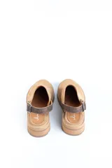 Zuecos de cuero color beige, con suela track y tira trasera ajustable.