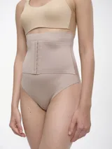 Bombacha tipo colaless de tiro alto con efecto modelador, confeccionada en tejido elástico color beige con cierre frontal de ganchos.