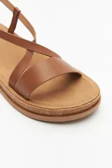 Sandalias negras con tiras cruzadas y hebilla ajustable, suela de corcho y plataforma.