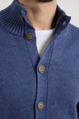 Cardigan de tejido de punto color azul piedra melange, con cuello mao y cierre frontal de botones.