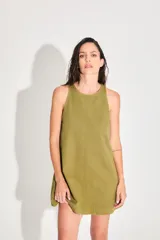 Vestido corto de gabardina color verde oliva, con escote cerrado y silueta amplia.