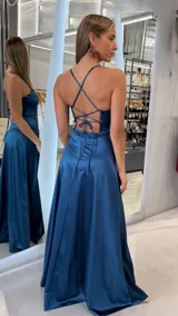 Vestido largo de satén azul marino, con tirantes finos, escote recto y tajo lateral en la pierna.