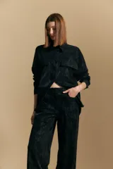 Pantalón de corte ancho y silueta relajada, confeccionado en tejido de efecto gamuzado color marrón oscuro. Presenta un diseño de tiro alto con cierre frontal y bolsillos laterales.