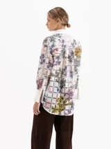 Camisa de manga larga confeccionada en poplín de encaje con diseño de cuadrados y estampado floral multicolor. Presenta cuello clásico, cartera oculta con botones, bolsillos plaque en el frente y puños anchos en color blanco liso.