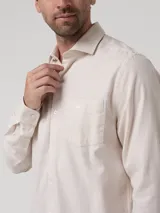 Camisa de manga larga RKF modelo Flasquare, color beige con sutil patrón a cuadros, cuello camisero, cierre frontal con botones y un bolsillo ojal en el pecho con el logo bordado de la marca.