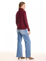 Polera de tejido fino, color rosado, con cuello alto, manga larga y detalle de tajo en los puños.