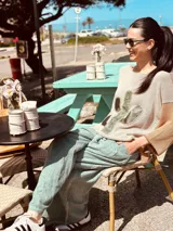 Sweater de punto color beige con mangas ranglan color marrón y aplique de cuero con forma de cactus en el frente.