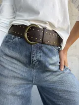 Cinto estilo faja color marrón chocolate, confeccionado en cuero sintético con detalle de tachas metálicas doradas y hebilla redonda grande de metal envejecido.