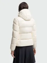 Chaqueta puffer Moncler modelo Glareins en color blanco, con diseño acolchado, cuello alto y capucha. Presenta cierre frontal con botones a presión, un bolsillo con solapa en el pecho y bolsillos laterales con cierre de cremallera.