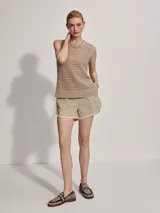 Musculosa de punto color beige con diseño calado y aberturas laterales.