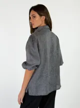 Camisa de lino color beige, con mangas abullonadas tres cuartos y cierre frontal de botones.