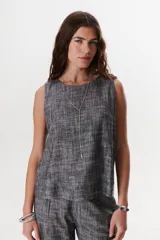 Top sin mangas de corte recto y holgado, confeccionado en tejido de lino con textura jaspeada en tono azul. Presenta cuello redondo y un diseño minimalista ideal para climas cálidos.