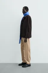 Pantalón chino de corte regular fit, confeccionado en tejido de algodón con elasticidad. Presenta bolsillos frontales, bolsillos traseros de vivo y cierre frontal con cremallera y botón.