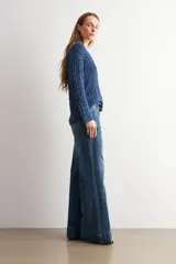 Pantalón de jean wide leg en color blanco, de tiro alto y corte ancho con dobladillo ancho en los bajos.