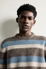 Sweater de punto con textura efecto pelo, cuello redondo, manga larga y diseño a rayas horizontales en tonos marrón, celeste y beige.