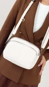 Bandolera de símil cuero color rojo, con doble bolsillo principal, un bolsillo frontal y un bolsillo trasero. Incluye correa ajustable.