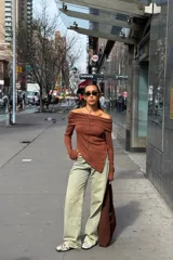 Remera color marrón con textura acanalada, corte asimétrico y hombros descubiertos.