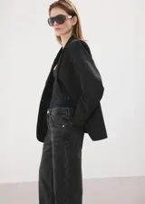 Jeans de denim 100% algodón en color gris oscuro con efecto deslavado, tiro medio y corte recto de pernera ancha.