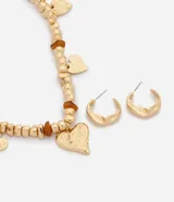 Conjunto de bisutería color dorado, compuesto por un collar de cuentas con dijes colgantes en forma de corazón y aros abridores texturados.
