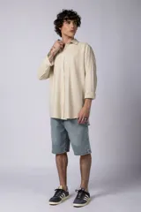 Camisa de manga larga confeccionada en lino, color verde oliva, con cuello clásico y cierre frontal de botones.