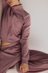 Campera deportiva de felpa de algodón color rosado, con corte ajustado, cuello elevado, cierre frontal completo y puños y bajo acanalados.