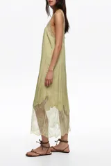Vestido midi verde claro de línea A con escote redondeado, tirantes y detalles de encaje transparente superpuesto en el escote y el bajo.