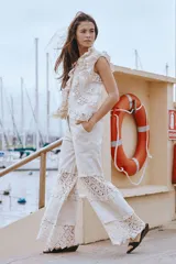 Pantalón de lino color beige, de corte ancho, con detalles de inserciones de crochet y volados en las piernas.