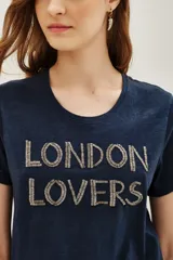 Remera azul marino de algodón con cuello redondo y mangas cortas. Presenta la frase 'LONDON LOVERS' bordada en el frente con cuentas metálicas.
