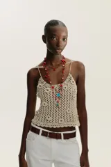 Pack de tres collares de cordones trenzados en tonos rojo y negro, adornados con cuentas de diferentes colores y dijes colgantes: corazones rojos, un dije azul turquesa con forma de pez, un dije azul verdoso con forma de corazón y un dije dorado con textura de concha.