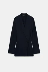 Blazer de corte fluido confeccionada en mezcla de viscosa, con cuello solapa, manga larga con puños abotonados y cierre frontal cruzado con botón único.