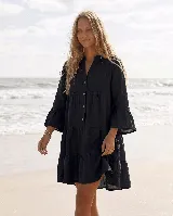Vestido corto de lino negro con diseño amplio, cuello en V con botones de coco y mangas tres cuartos terminadas en volados.