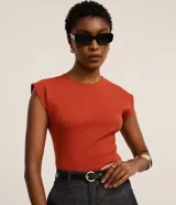 Blusa de canalé color naranja, de corte ajustado, con cuello redondo y hombreras marcadas sin mangas.