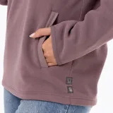 Buzo polar de microfleece color rosa viejo, con cuello alto, cierre frontal parcial con botones a presión y bolsillo frontal tipo canguro. Presenta detalles en nylon en la tapeta y los bolsillos, y puños con sujeción elástica.