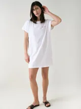 Camisón blanco de algodón, de corte holgado, manga corta y largo por encima de las rodillas. Presenta una pequeña estampa localizada en el pecho y aberturas en los laterales.