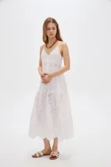 Vestido midi blanco de algodón con diseño broderie, tirantes finos, escote en V y cierre frontal con botones.