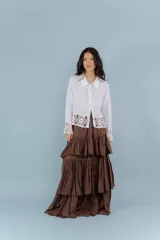 Camisa de lino blanca con detalles de encaje crochet en los puños y en el ruedo. Presenta un diseño romántico con cierre frontal de botones.