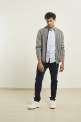 Cardigan de punto color azul marino, con cierre frontal de metal y cuello alto. Presenta tejido de punto fantasía y bolsillos laterales.