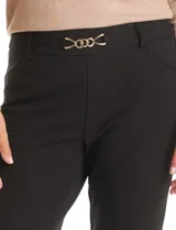 Pantalón de vestir marca Zac & Rachel confeccionado en crepe elastizado. Presenta un diseño de tiro alto con silueta de pierna recta, pretina con pasadores y un aplique decorativo de cadena dorada en la parte frontal. Incluye bolsillos laterales.